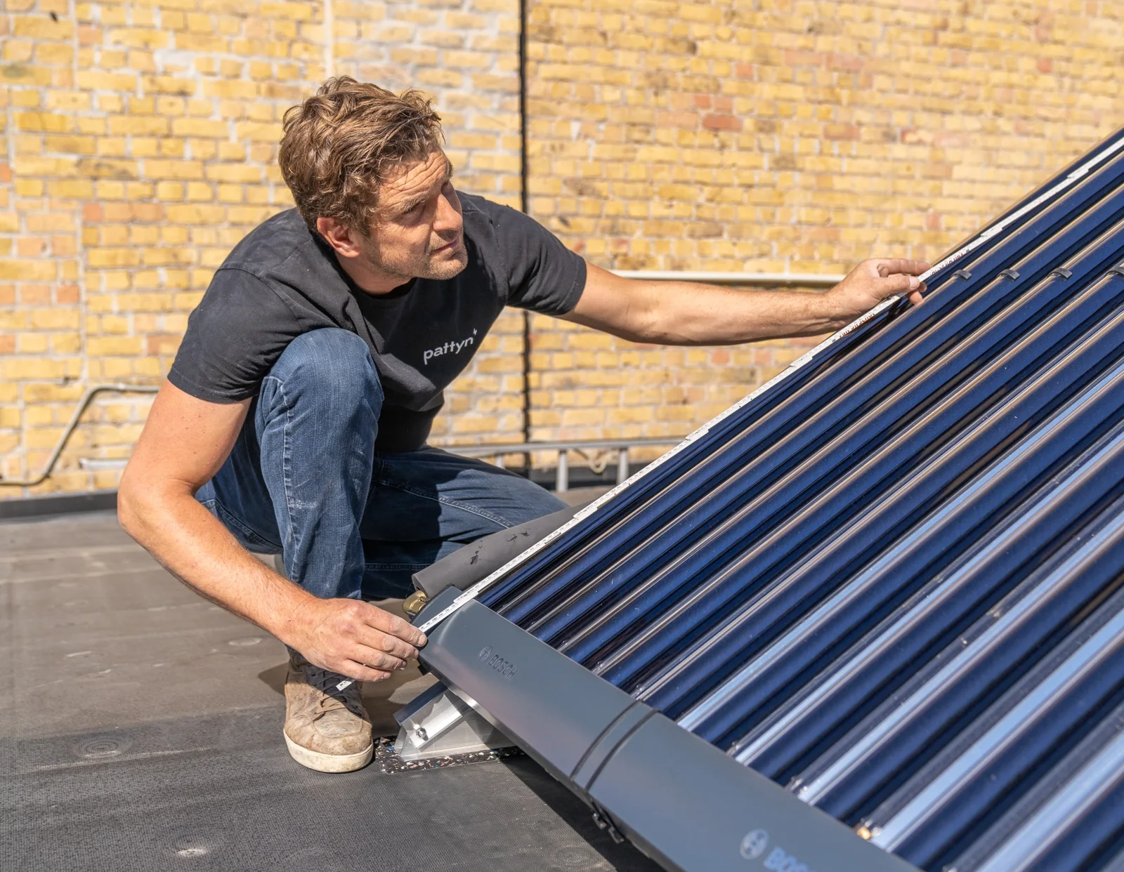 Pattyn-technieker controleert een thermische zonnecollector