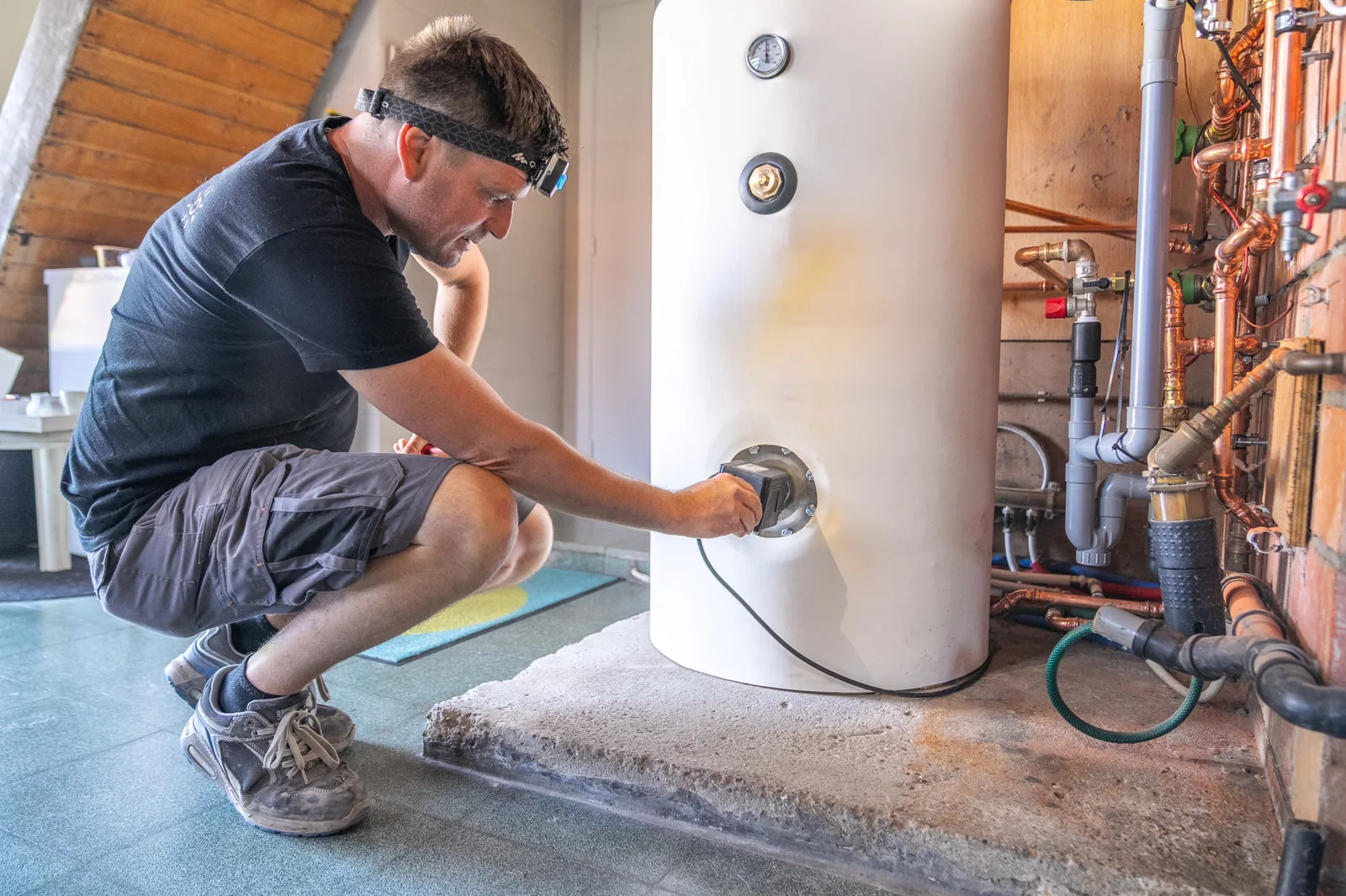 Pattyn-technieker aan een warmwatervat met aangesloten koperen leidingen