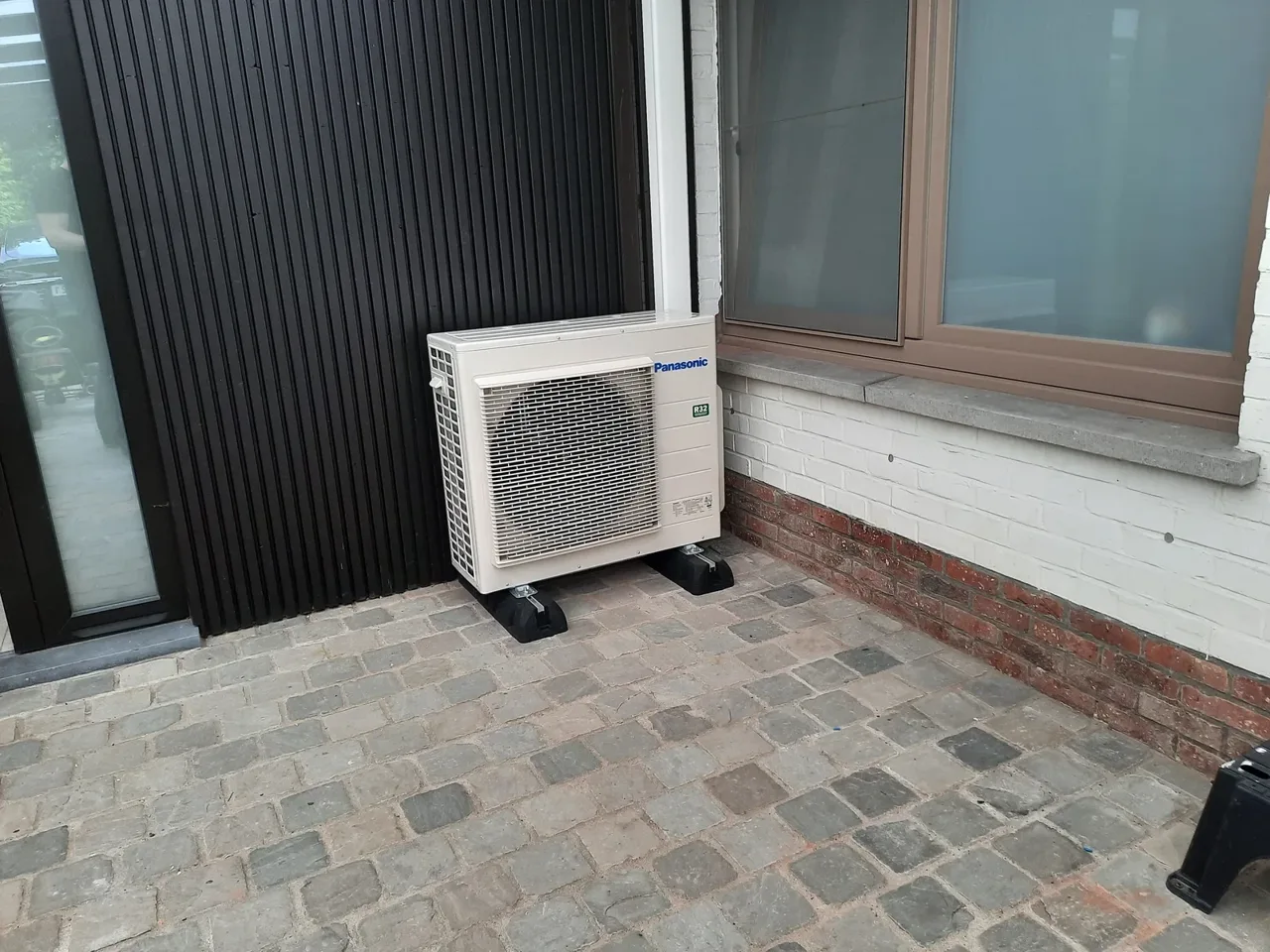 Panasonic-buitenunit tegen de gevel van een woning