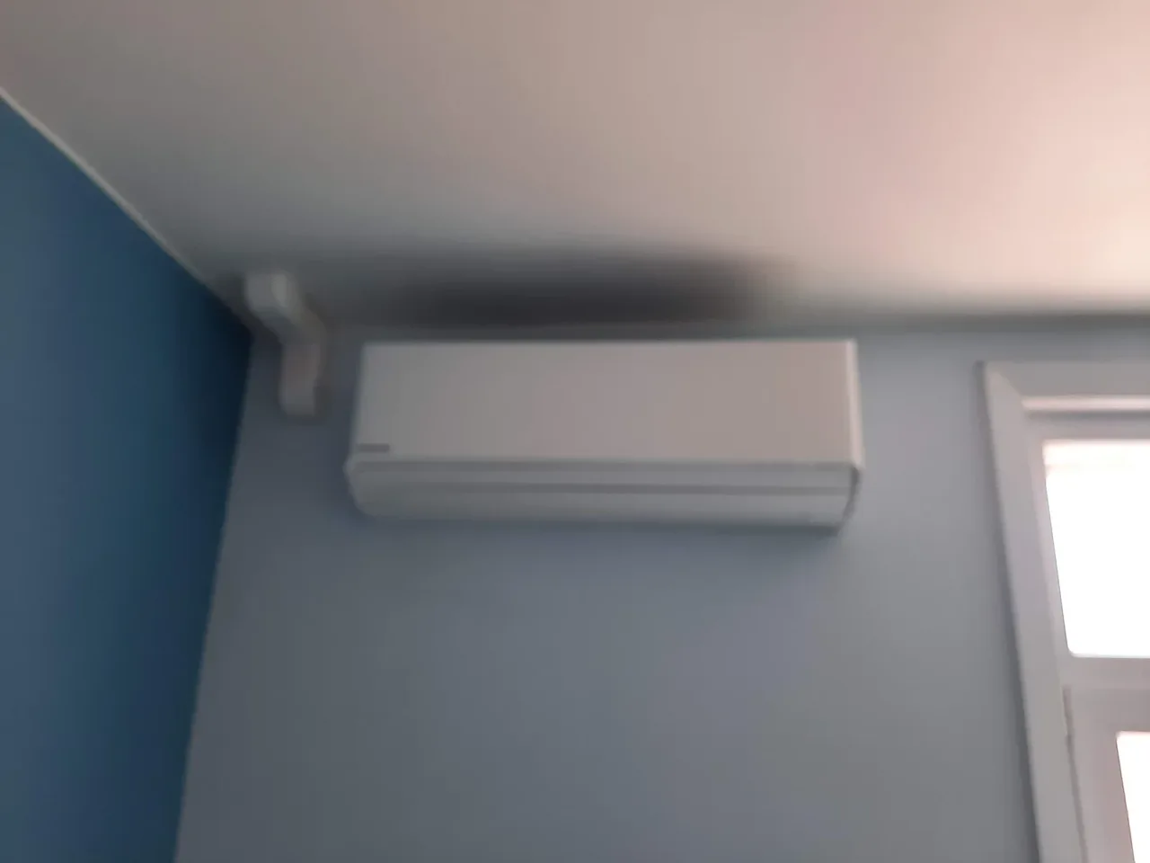 Panasonic-wandunit bovenaan een blauwe kamer