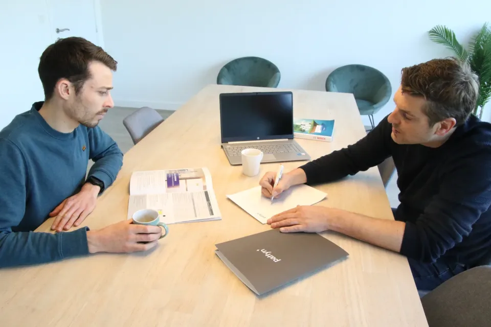 Twee mensen in gesprek aan tafel bij Pattyn