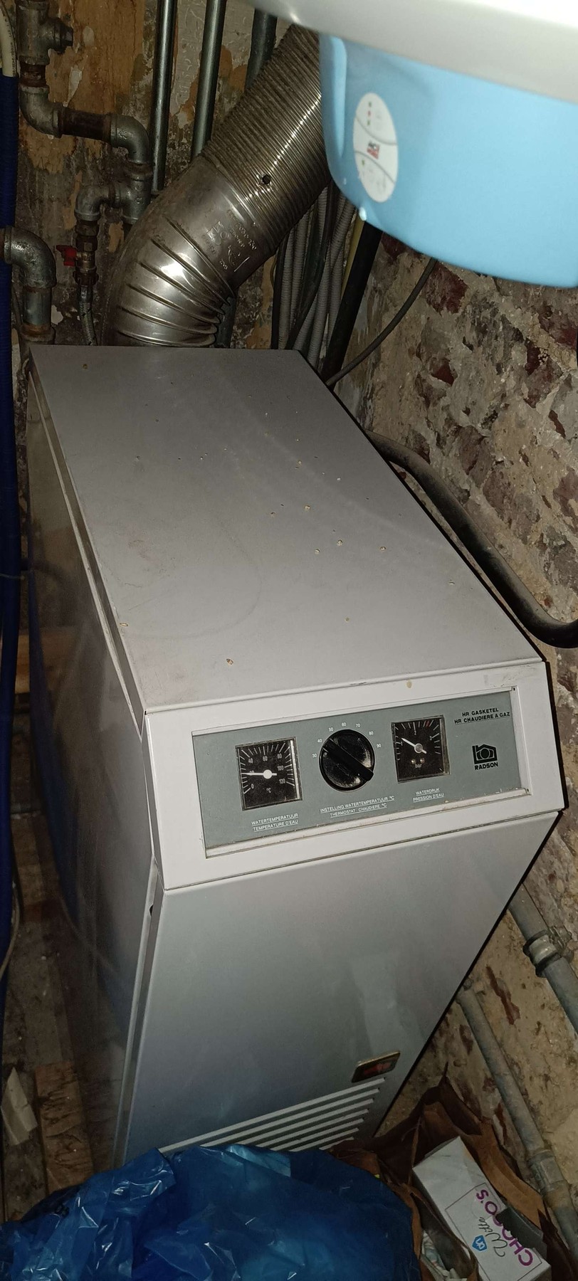 Vloerstaande Radson-gasketel onder de aparte elektrische boiler vóór de vervanging in Gent