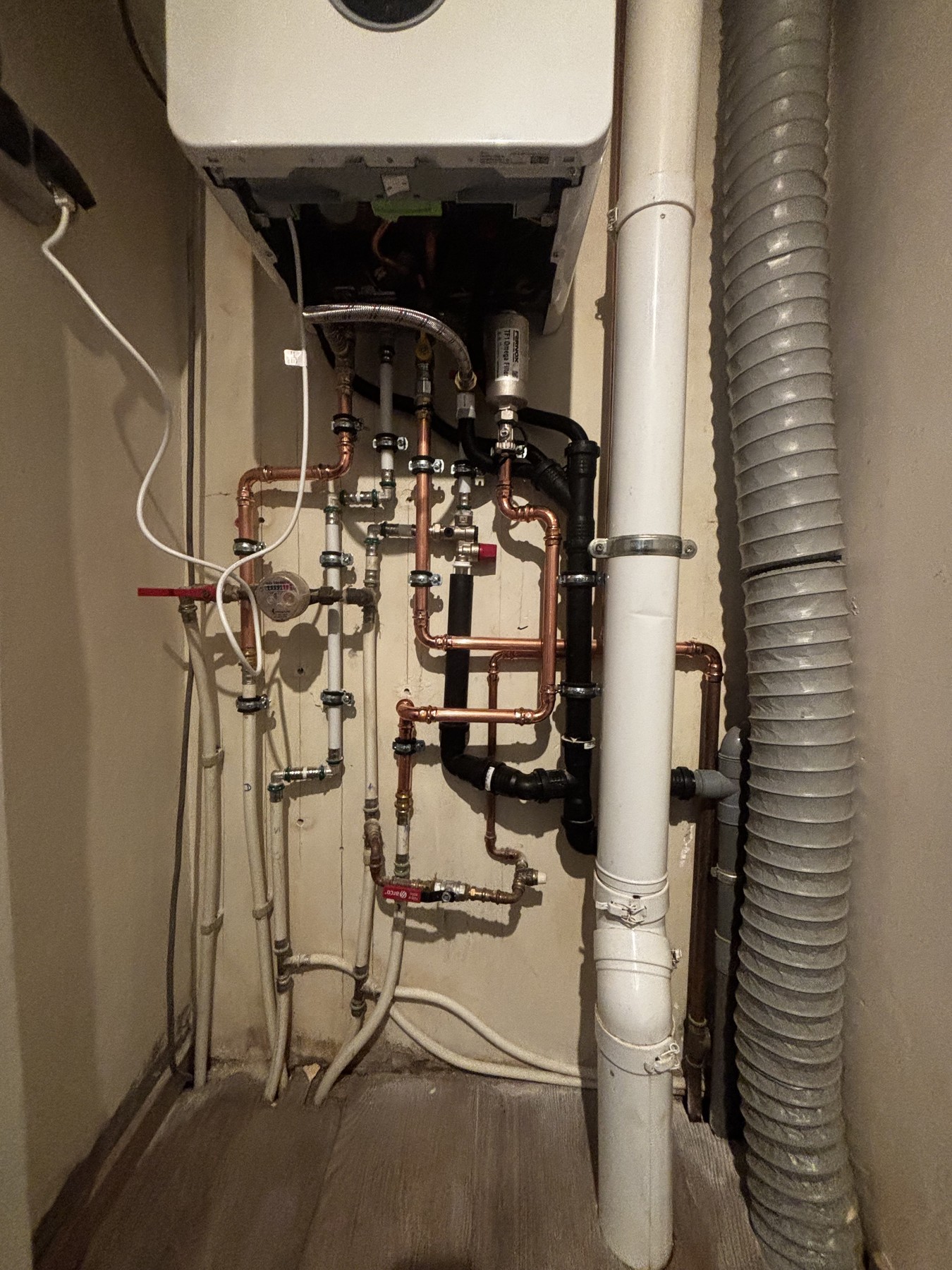 Detail van de leidingaansluitingen onder de geopende Bosch-ketel