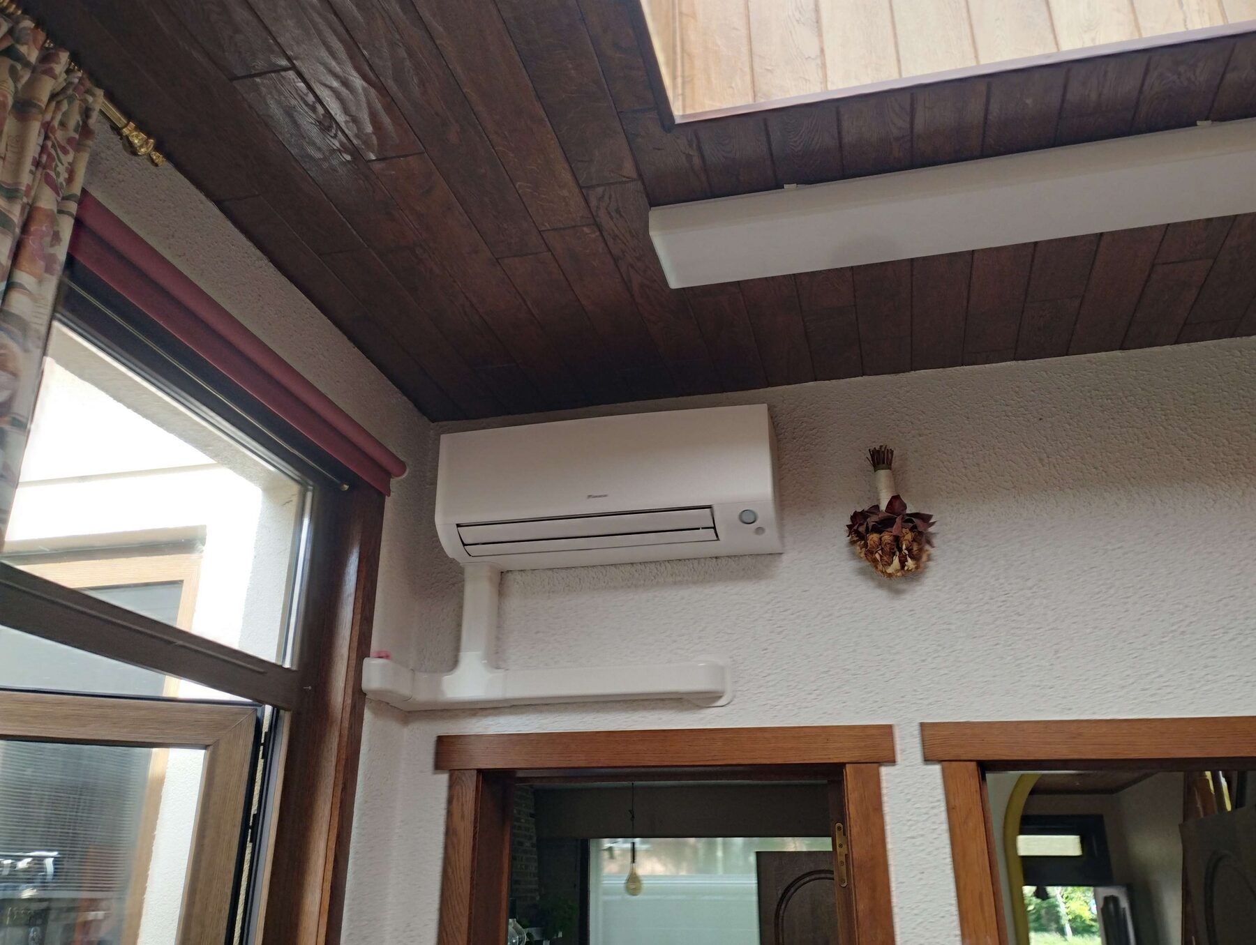 Daikin-wandunit hoog aan de muur in een woonruimte in Kortrijk