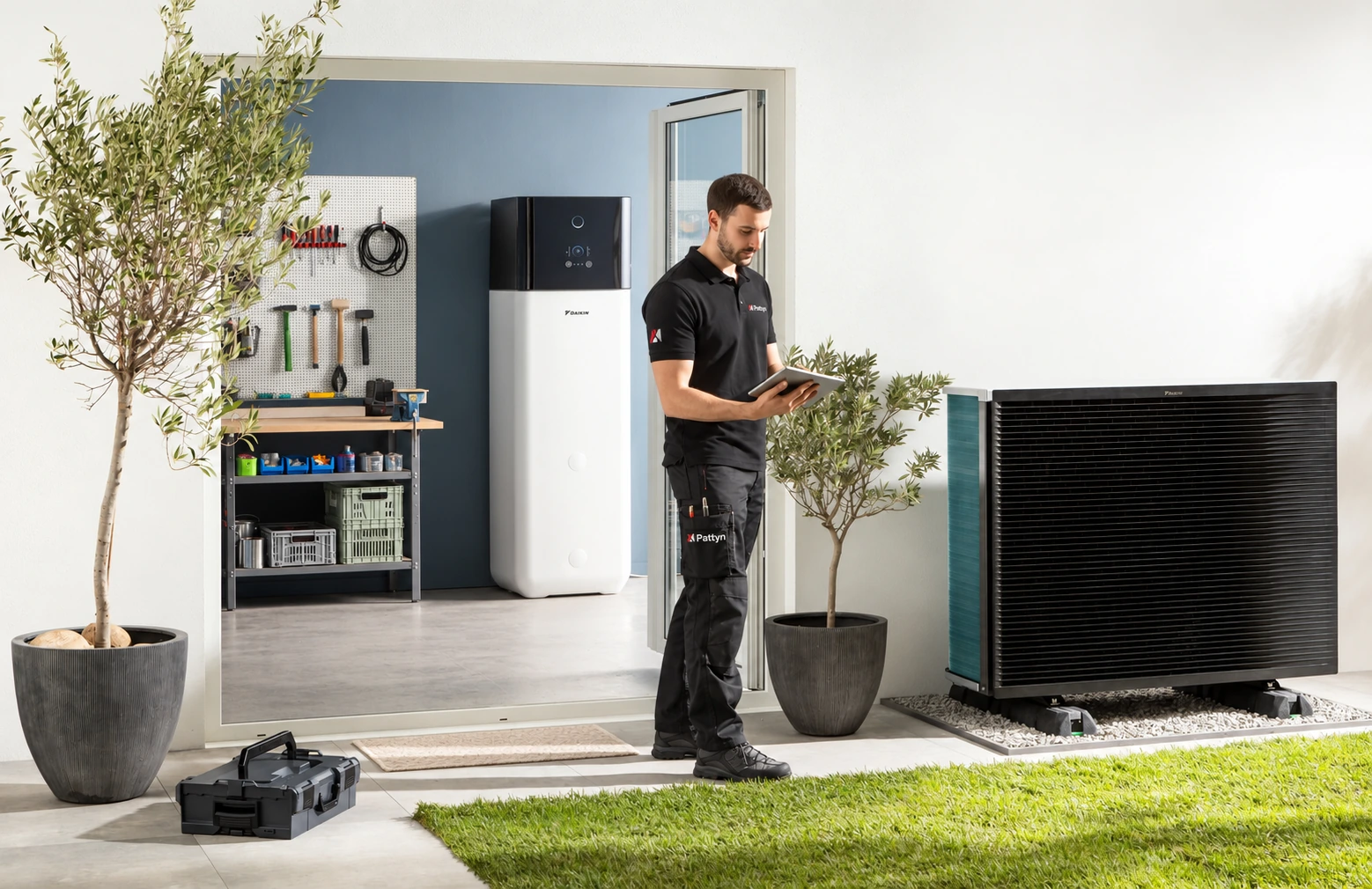 Warmtepomptechnieker met tablet bij een moderne woning met binnen- en buitenunit
